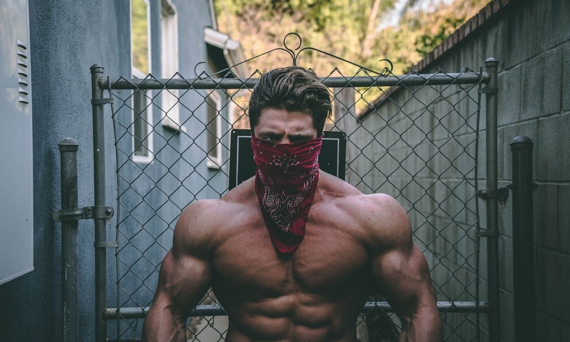 Muscle Bound guy with a handkerchief around mouth showing off shredded and muscular physique